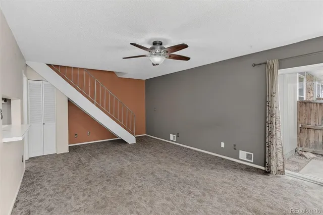 an empty room with ceiling fan and entryway