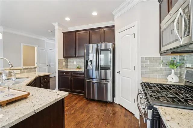 a kitchen with stainless steel appliances granite countertop a sink stove and refrigerator