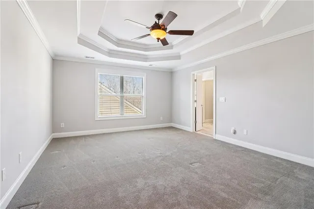 an empty room with a window and a ceiling fan