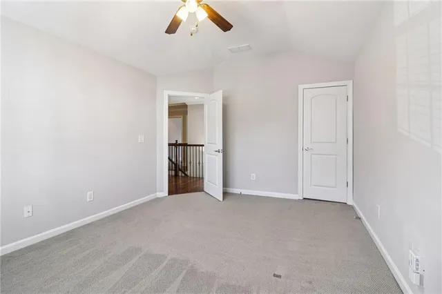 an empty room with chandelier fan