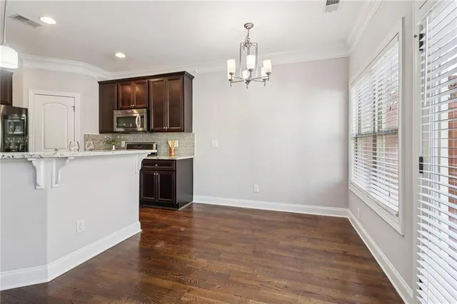 a view of kitchen with kitchen island stainless steel appliances refrigerator stove microwave and cabinets