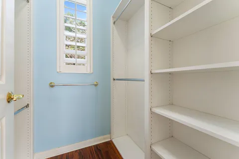 a kitchen with white cabinets and window