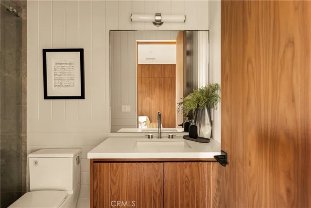 a bathroom with a sink a toilet and mirror