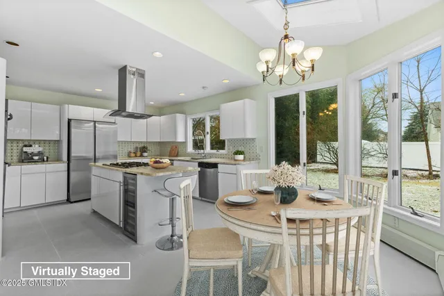 a kitchen with a refrigerator a stove a sink dishwasher a dining table and chairs with wooden floor