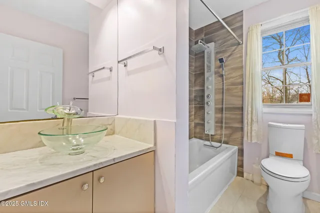 a bathroom with a granite countertop sink toilet and shower