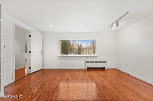 wooden floor in an empty room with a window