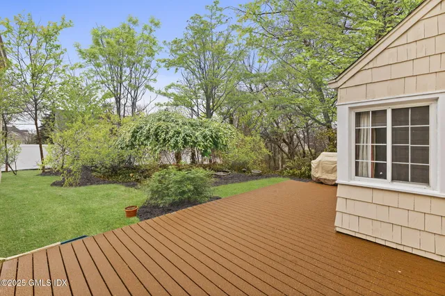 a view of a backyard with wooden floor and fence