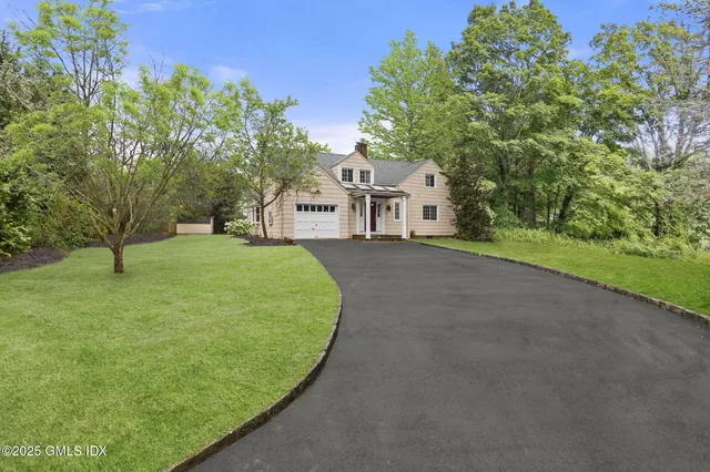 a view of a house with a yard and basketball court