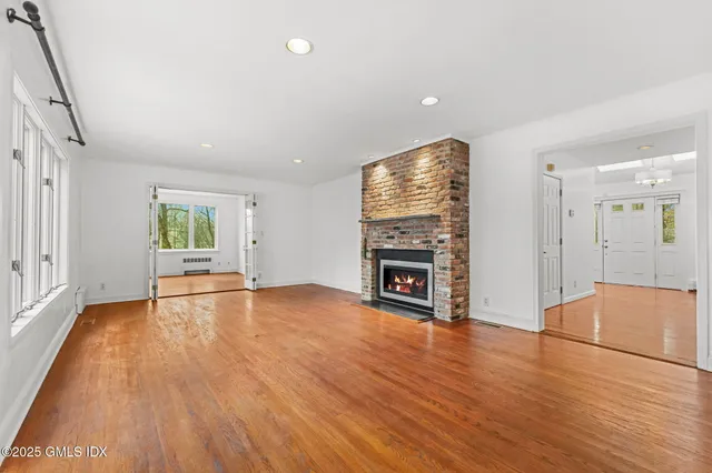 an empty room with wooden floor and fireplace