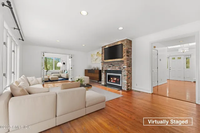 a living room with furniture a fireplace and a flat screen tv