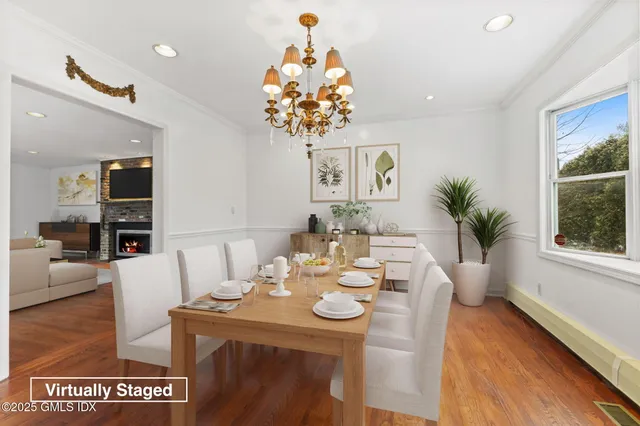 a view of a dining room with furniture a chandelier and wooden floor
