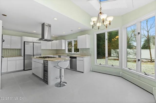 a large kitchen with a large window and stainless steel appliances