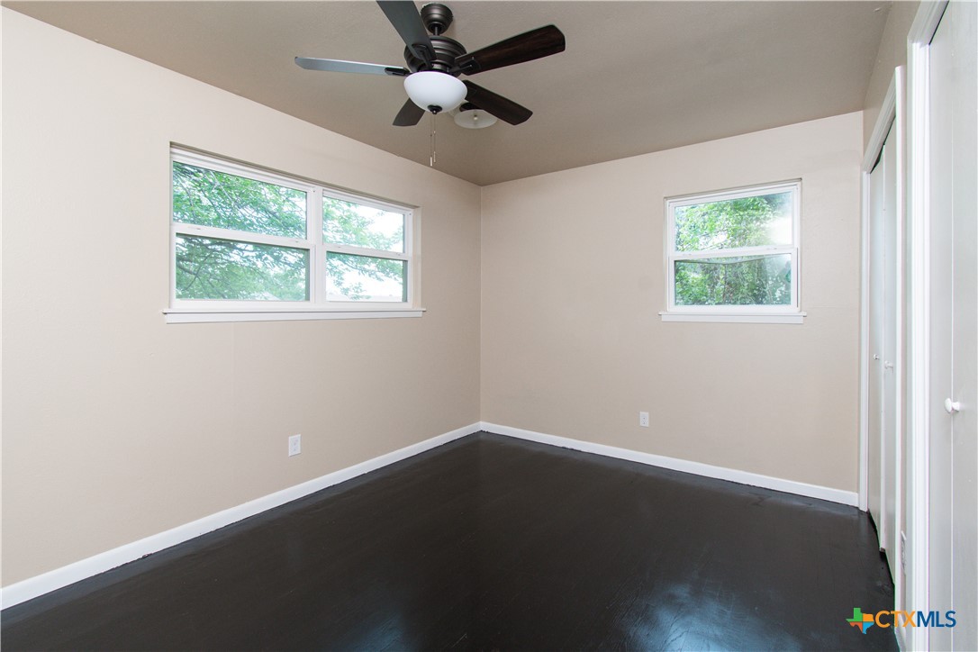 1312 Stephen Street Killeen, TX 76549 - Photo 15 of 19 an empty room with wooden floor ceiling fan and windows