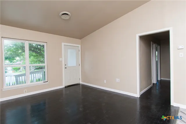 a view of a livingroom with wooden floor and a window