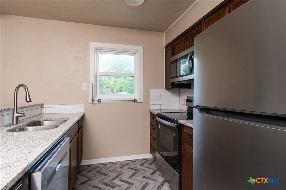 1312 Stephen Street Killeen, TX 76549 - Photo 7 of 19 a kitchen with stainless steel appliances granite countertop a sink stove and refrigerator