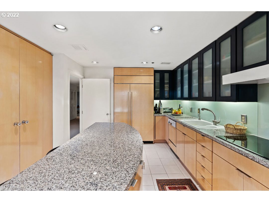 1414 Southwest 3rd Avenue, Unit 2903 Portland, OR 97201 - Photo 27 of 30 a kitchen with stainless steel appliances kitchen island granite countertop a refrigerator and cabinets