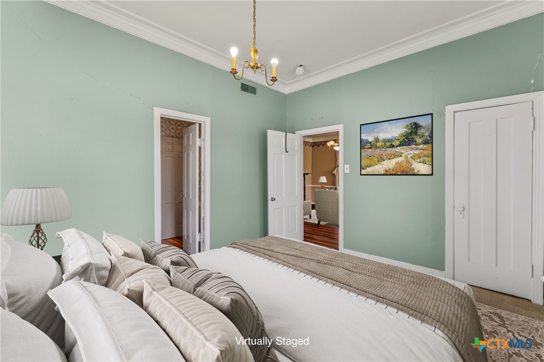 2967 South Old Robinson Road Lorena, TX 76655 - Photo 24 of 41 a bedroom with a large bed and a chandelier