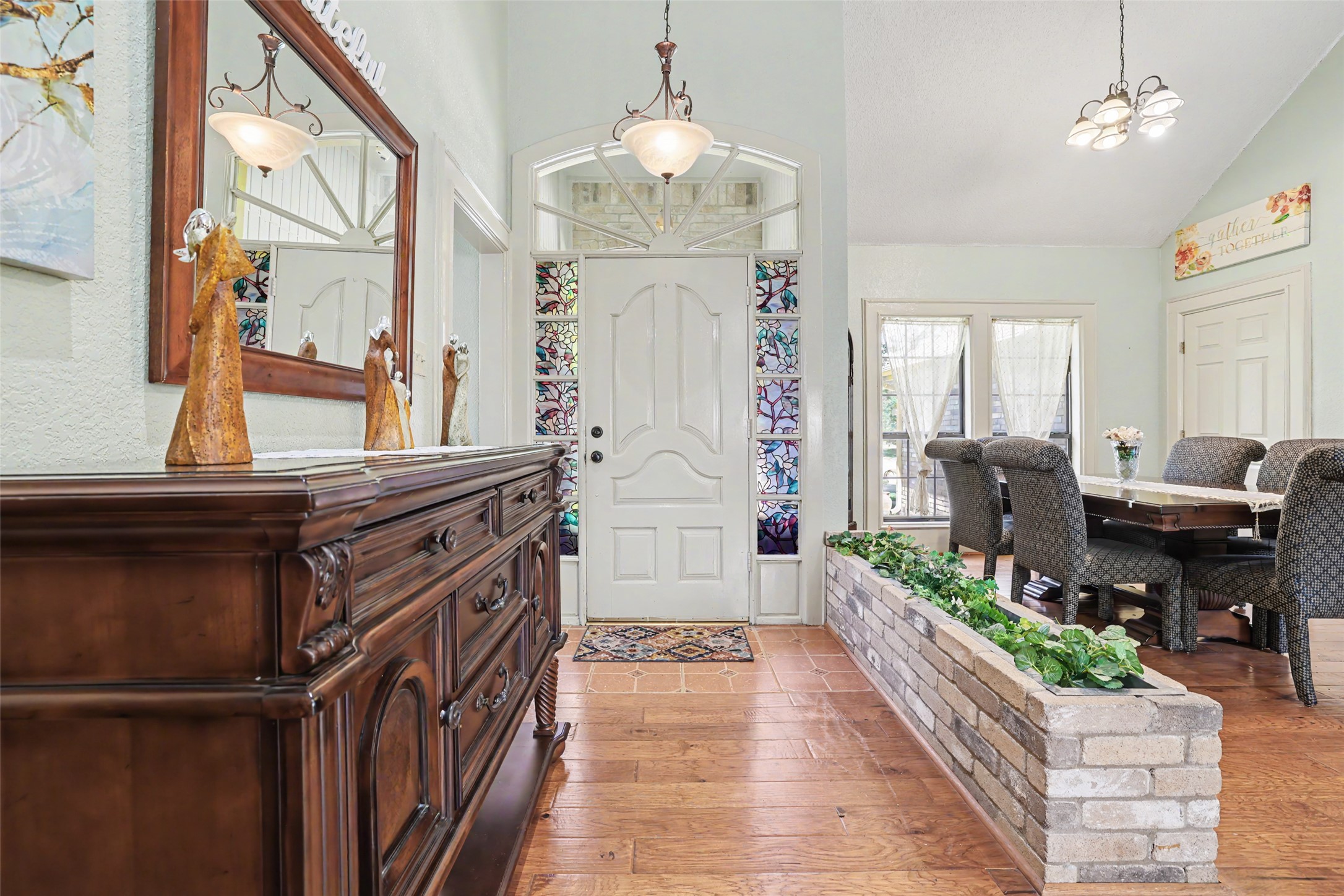 110 South Ridge Circle Georgetown, TX 78628 - Photo 4 of 37 Entryway featuring a white paneled door with decorative sidelights and an arched transom, wood-finish flooring, a brick planter with built-in greenery, and a vaulted ceiling