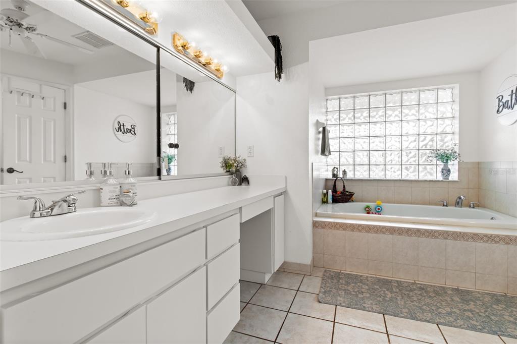 5301 Merrifield Court Spring Hill, FL 34608 - Photo 15 of 46 a bathroom with a sink a bathtub a mirror a vanity and a shower