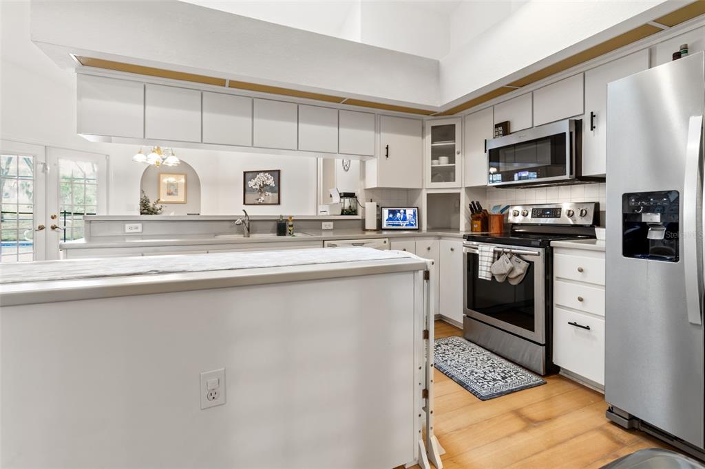 5301 Merrifield Court Spring Hill, FL 34608 - Photo 20 of 46 a kitchen with stainless steel appliances granite countertop a stove a sink and a microwave