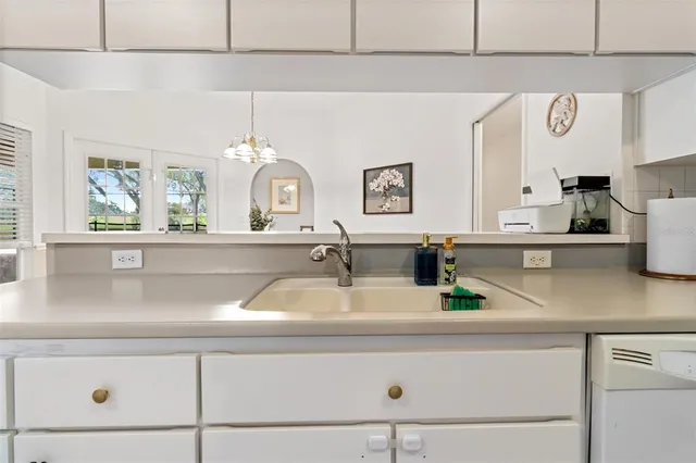 a kitchen with a sink and a clock on the wall