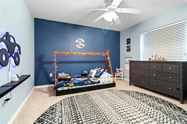 a bath room with a granite countertop sink a toilet a mirror and a window