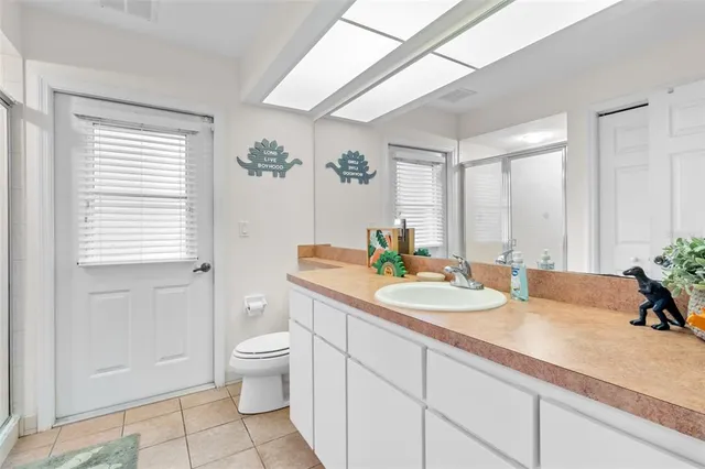a bathroom with a granite countertop sink mirror vanity and toilet