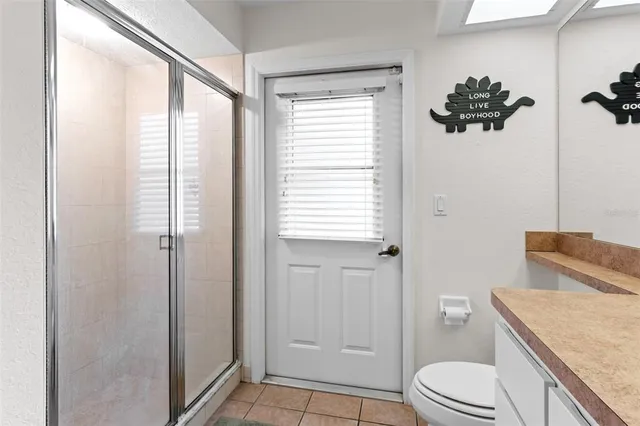 a living room with a bed furniture flat screen tv and a window