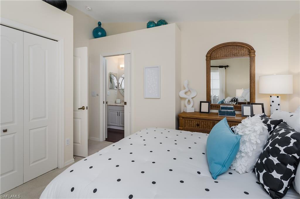 6658 Castlelawn Place, Unit 9 Naples, FL 34113 - Photo 22 of 38 Bedroom featuring a rattan headboard, carpet flooring, and a window with horizontal blinds and draperies