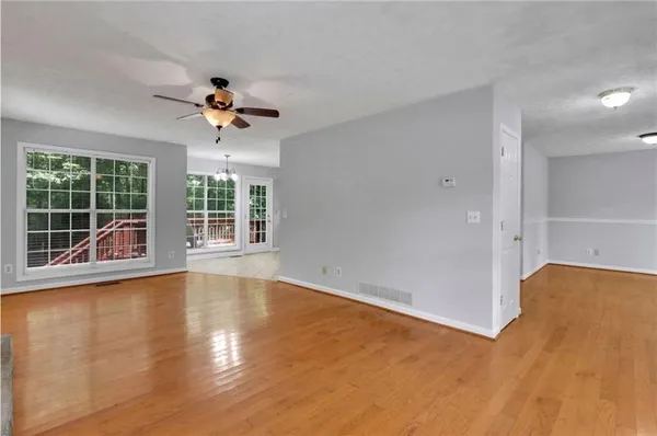 an empty room with wooden floor and windows