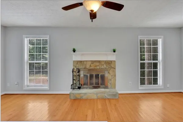 an empty room with windows and fireplace