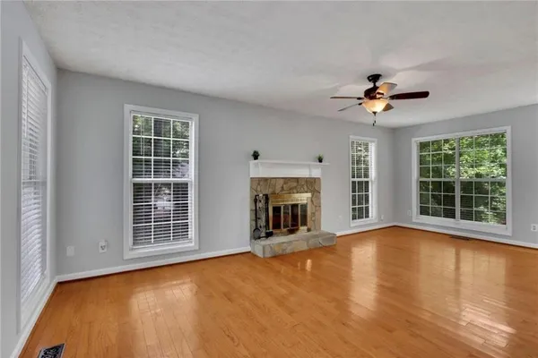 a view of an empty room with a fireplace and a window
