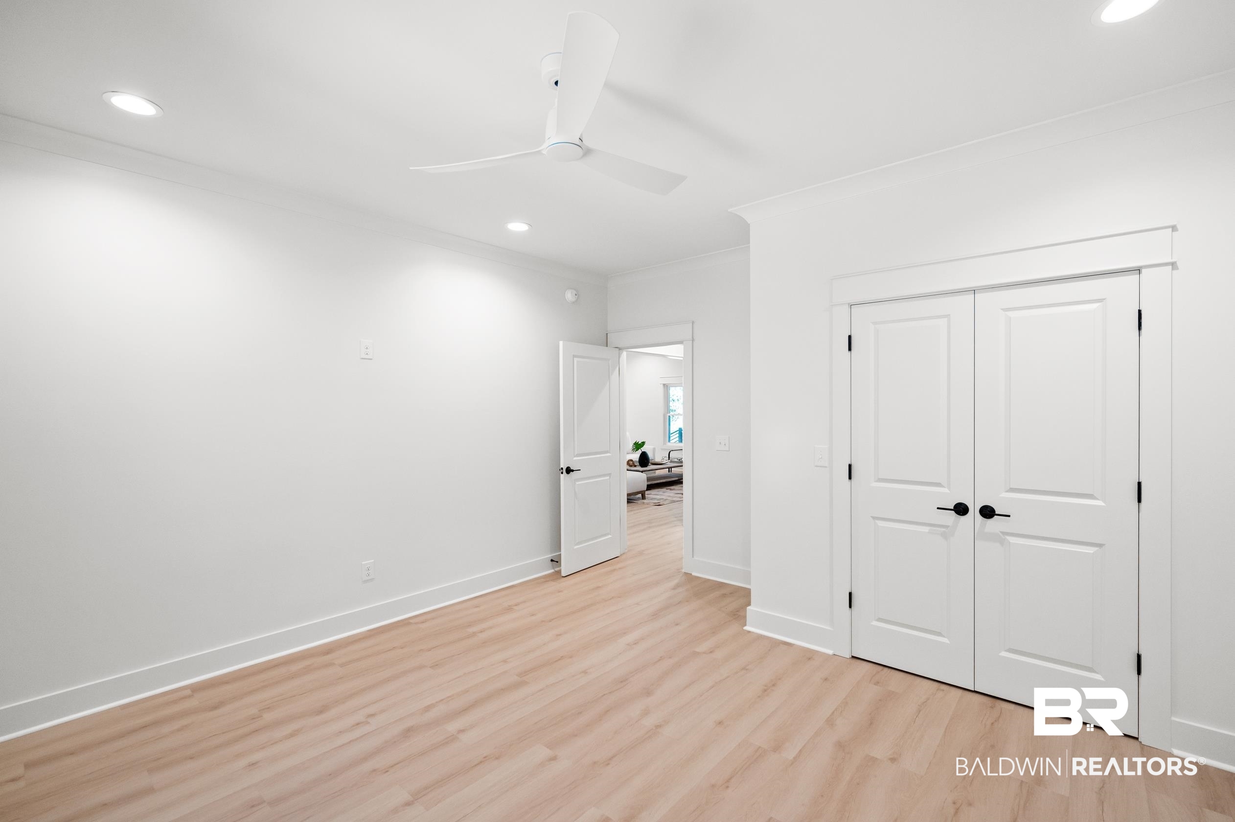 28889 Canal Road Orange Beach, AL 36561 - Photo 32 of 55 Unfurnished bedroom with ceiling fan, light wood-type flooring, ornamental molding, and a closet