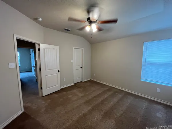 an empty room with closet and fan