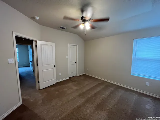 an empty room with closet and fan