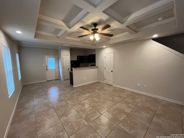 a view of an empty room with a fireplace and a ceiling fan