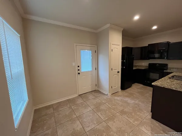 a view of kitchen with stainless steel appliances granite countertop a refrigerator and a sink