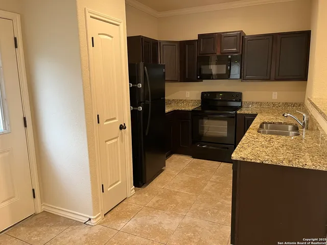a kitchen with granite countertop a refrigerator and a stove