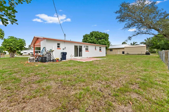 a view of a house with backyard and sitting area