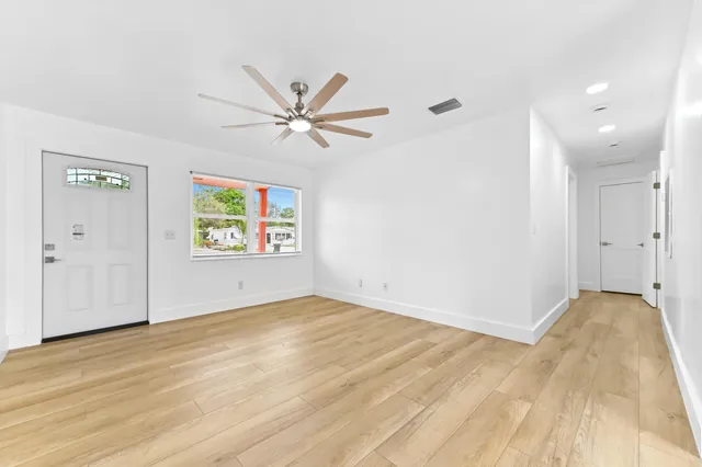 a view of empty room with wooden floor