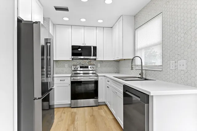 a kitchen with stainless steel appliances a refrigerator stove and sink