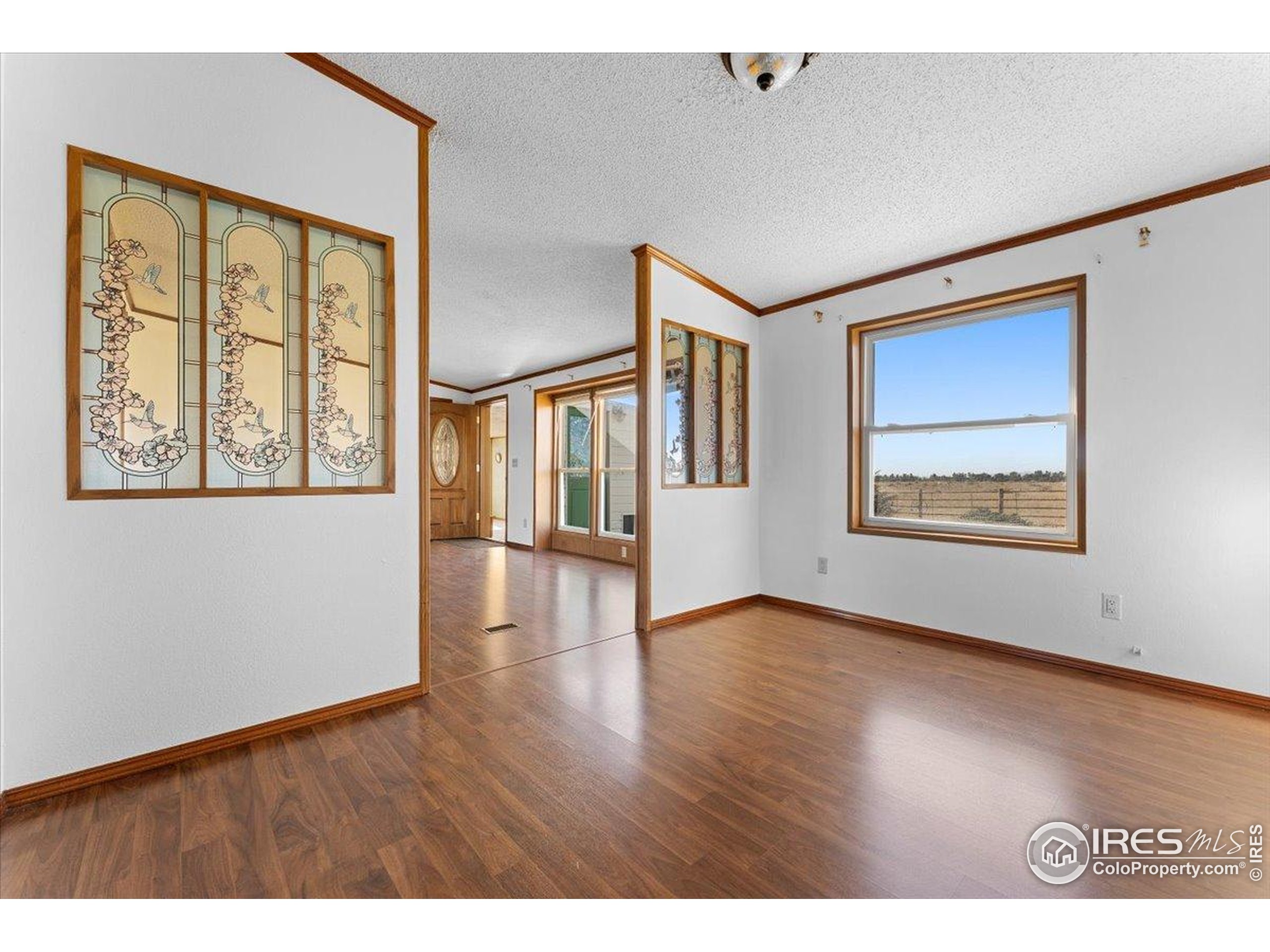 1721 West Co Road 68 Fort Collins, CO 80524 - Photo 34 of 50 a view of an empty room with wooden floor and a window