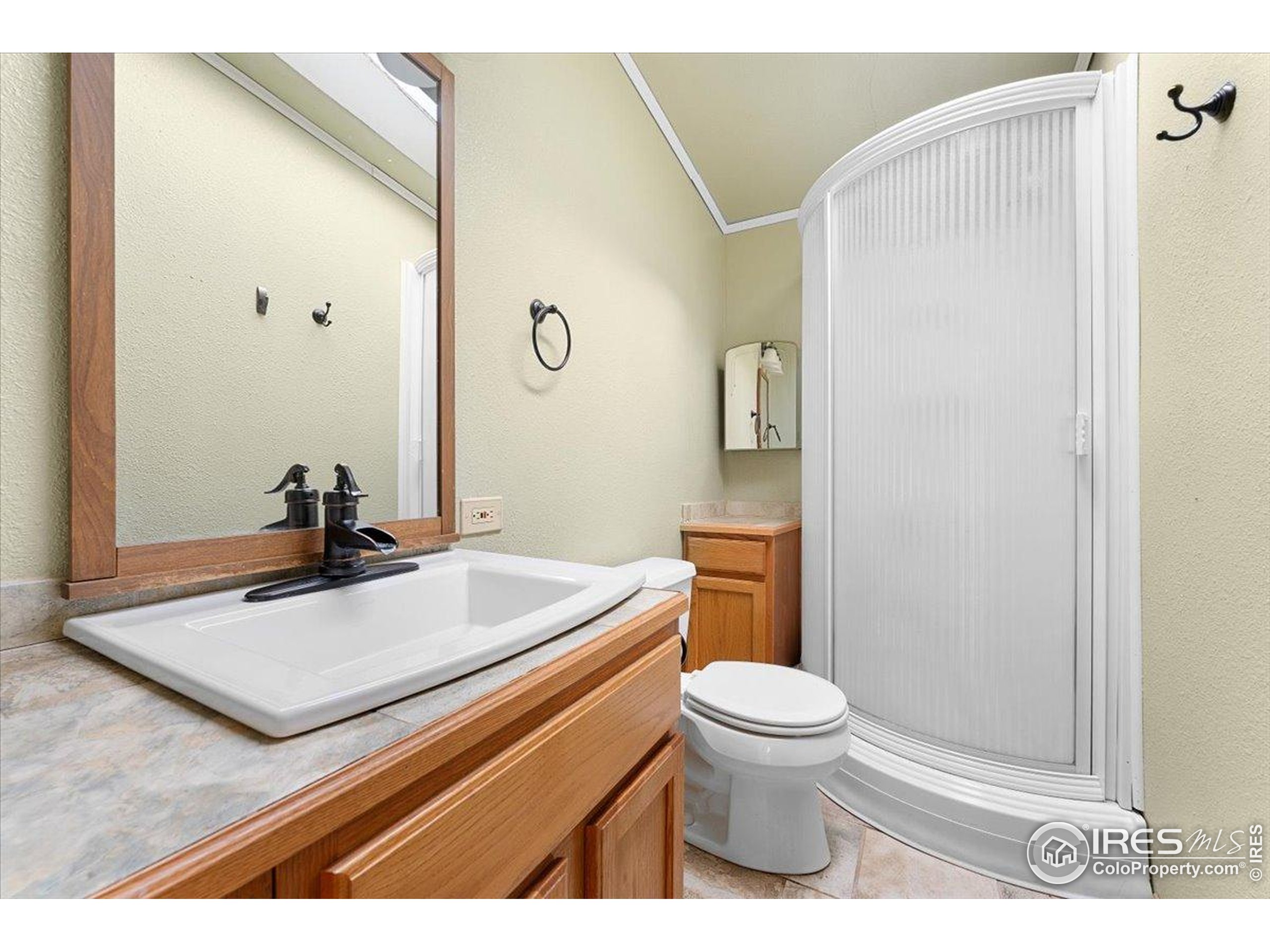 1721 West Co Road 68 Fort Collins, CO 80524 - Photo 40 of 50 a bathroom with a sink a toilet a mirror and shower