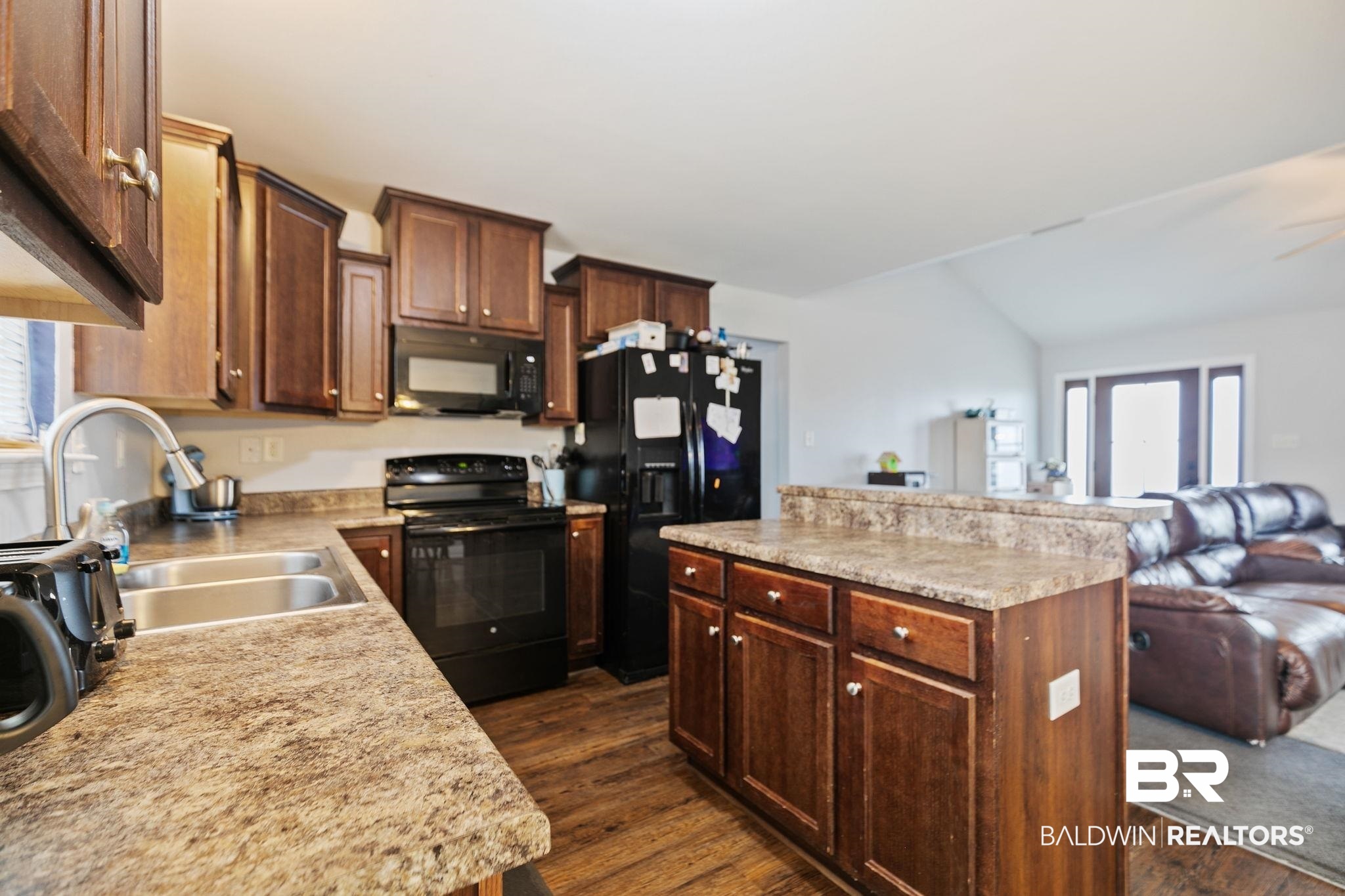 15573 Talus Court Foley, AL 36535 - Photo 17 of 50 Kitchen featuring lofted ceiling, dark wood-type flooring, a center island, black appliances, and sink