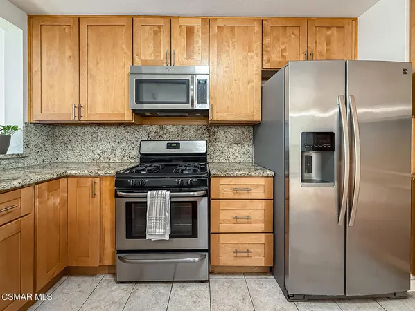 a kitchen with stainless steel appliances granite countertop a refrigerator stove and microwave