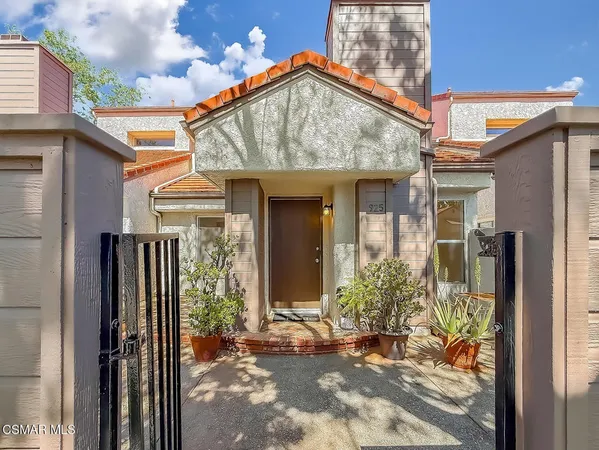 a view of a house with potted plants in front of door