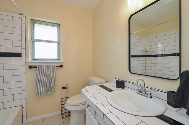 a bathroom with a sink toilet and mirror