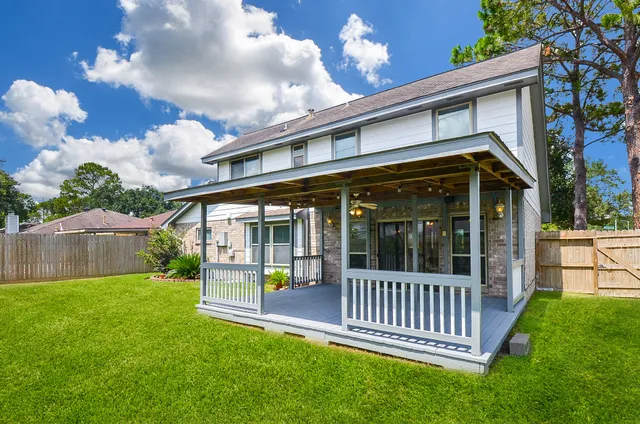 a view of a house with a small yard and deck