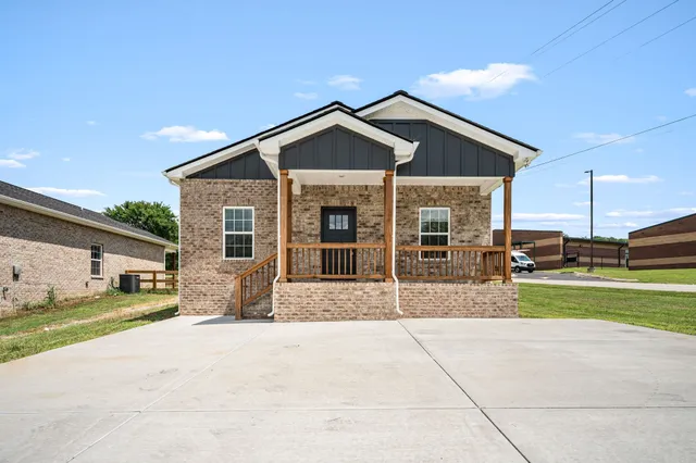 a view of a house with a yard and pathway