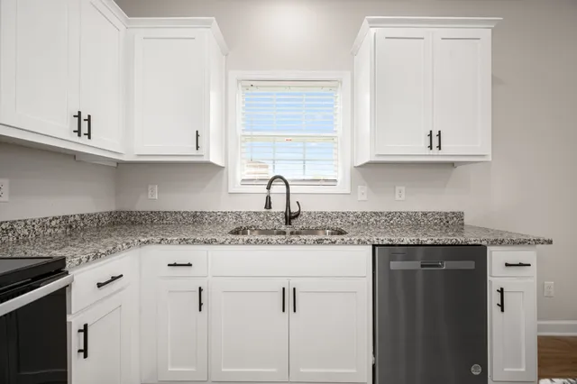 a kitchen with granite countertop a sink and cabinets